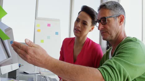 Side-view-of-Caucasian-Business-people-discussing-over-computer-at-desk-in-office-4k