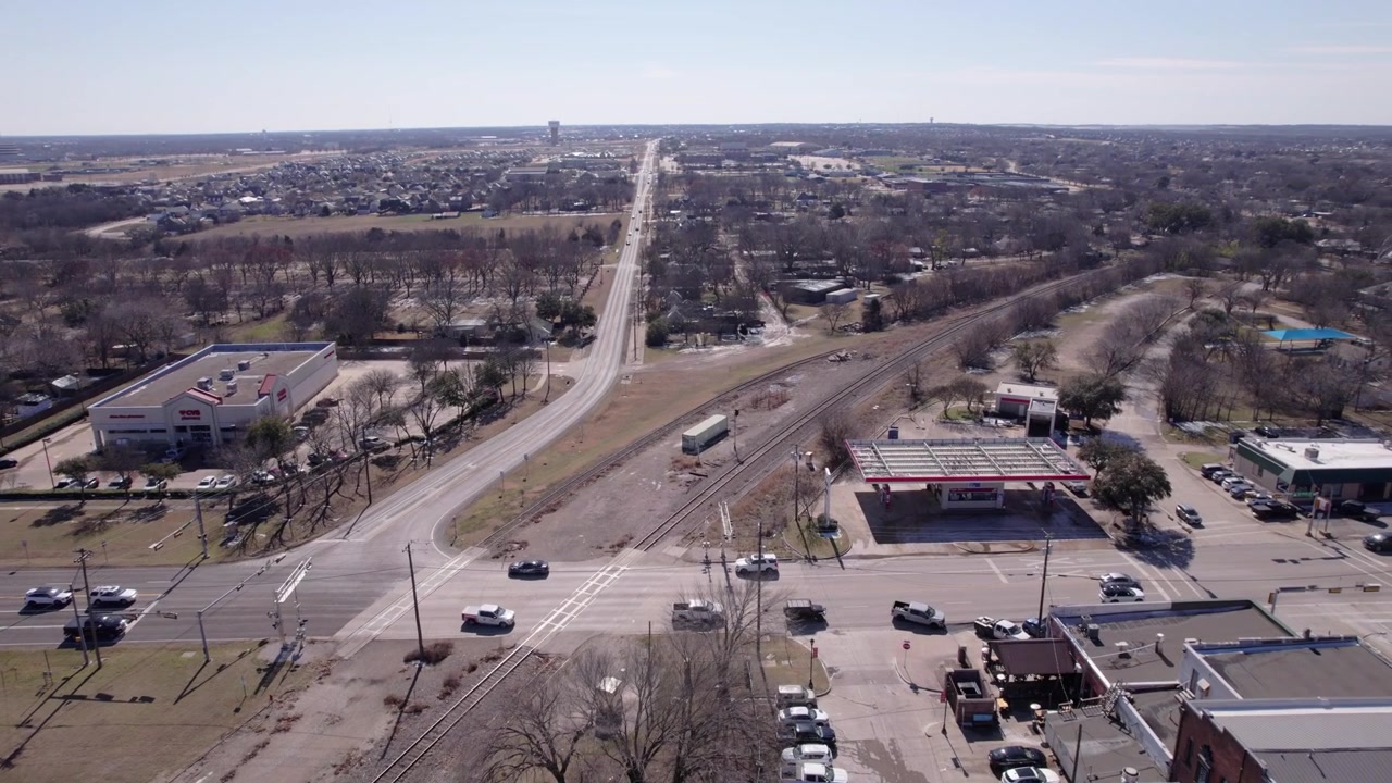 Riprese drone 4K che sorvolano i binari della ferrovia nel centro di Midlothian, Texas, catturando infrastrutture di trasporto, sviluppo urbano e il paesaggio cittadino del Texas settentrionale.