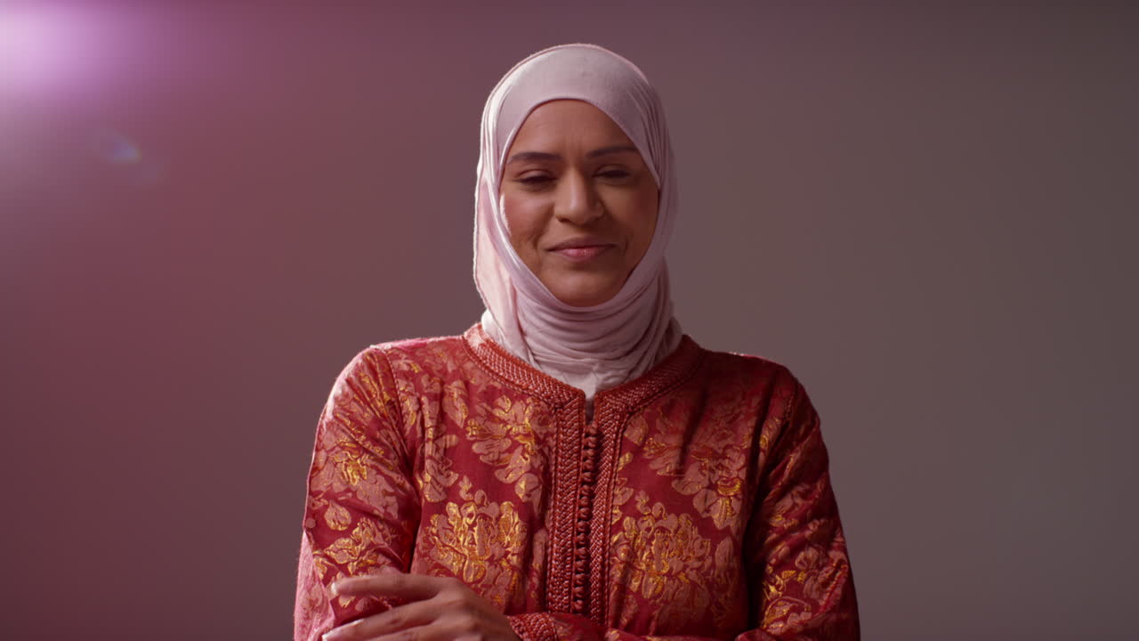 retrato de estudio de una mujer musulmana sonriente con hijab contra un fondo plano 4