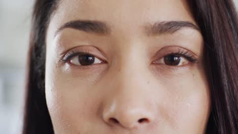 close up portrait of opening eyes of smiling biracial woman in slow motion