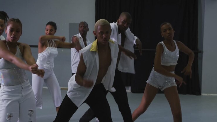 Multi-ethnic group of fit male and female modern dancers practicing dance routine