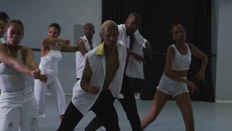 multi-ethnic group of fit male and female modern dancers practicing dance routine