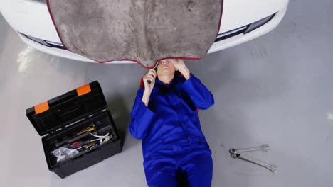 female mechanic servicing a car