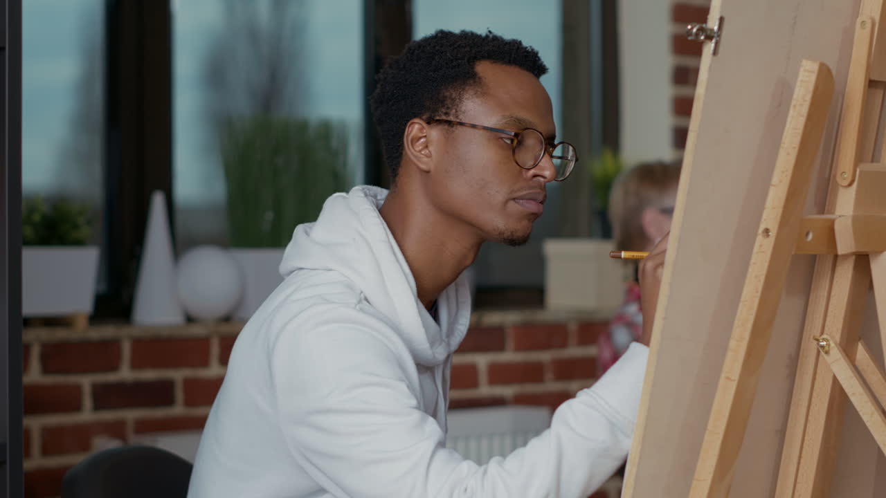 Giovane studente che crea opere d'arte moderne su aree di lavoro con una matita