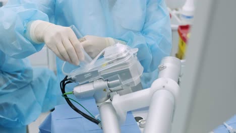 ophthalmological surgery specialist sits in front of microscope performing operation. low angle view on the female doctor conducting high-precision surgery. femto laser assisted cataract surgery.