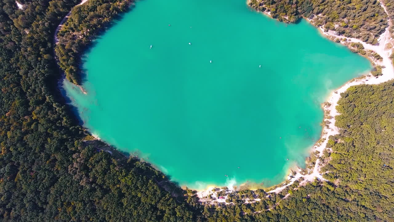 Aerial View of Turquoise Quarry Lake Surrounded by Forest