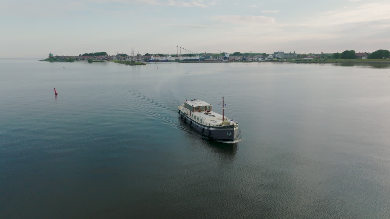 Aerial dolly in shot of the Dutch boat Luxe Motor leaves the port in Holland