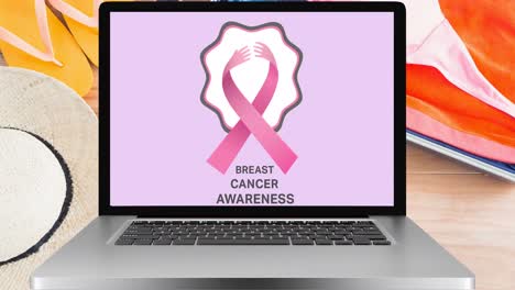 Animation-of-pink-ribbon-logo-and-breast-cancer-text-on-laptop-screen