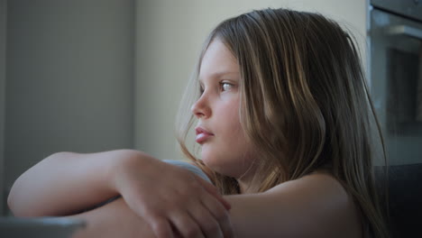 portrait of cute little blonde girl pensive in the kitchen