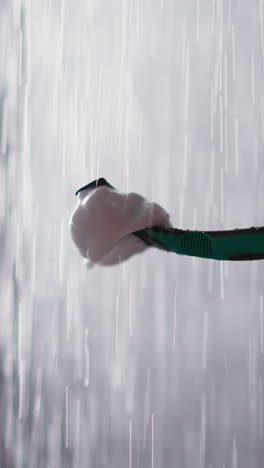 woman cleans razor in water sprays in bathroom closeup. lady washes blade under falling down drops in shower unit. cleaning shaver after usage