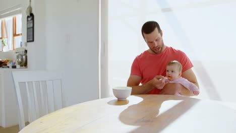 Father-feeding-his-baby-boy-with-spoon-4k
