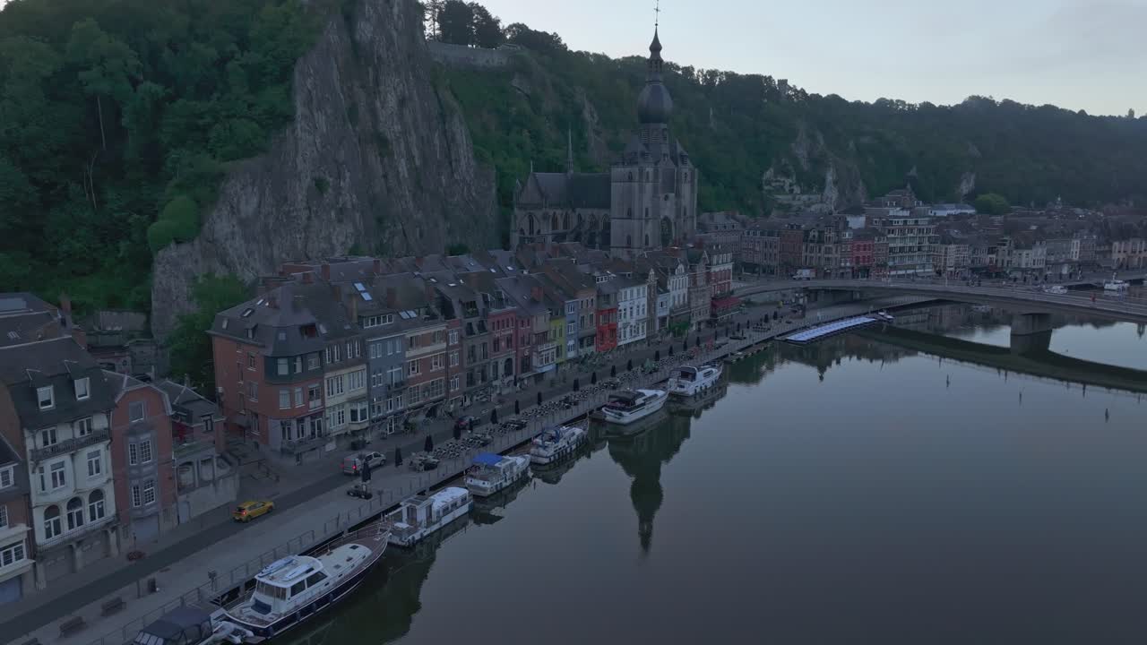 Veduta aerea di Dinant con la città, la cittadella e una barca, che mostra un paesaggio storico e sereno in Belgio.