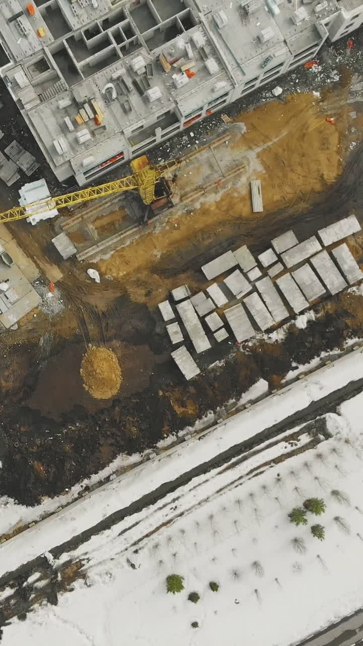 abandoned industrial construction site covered with thick snow layer and traces from building equipment bird eye view