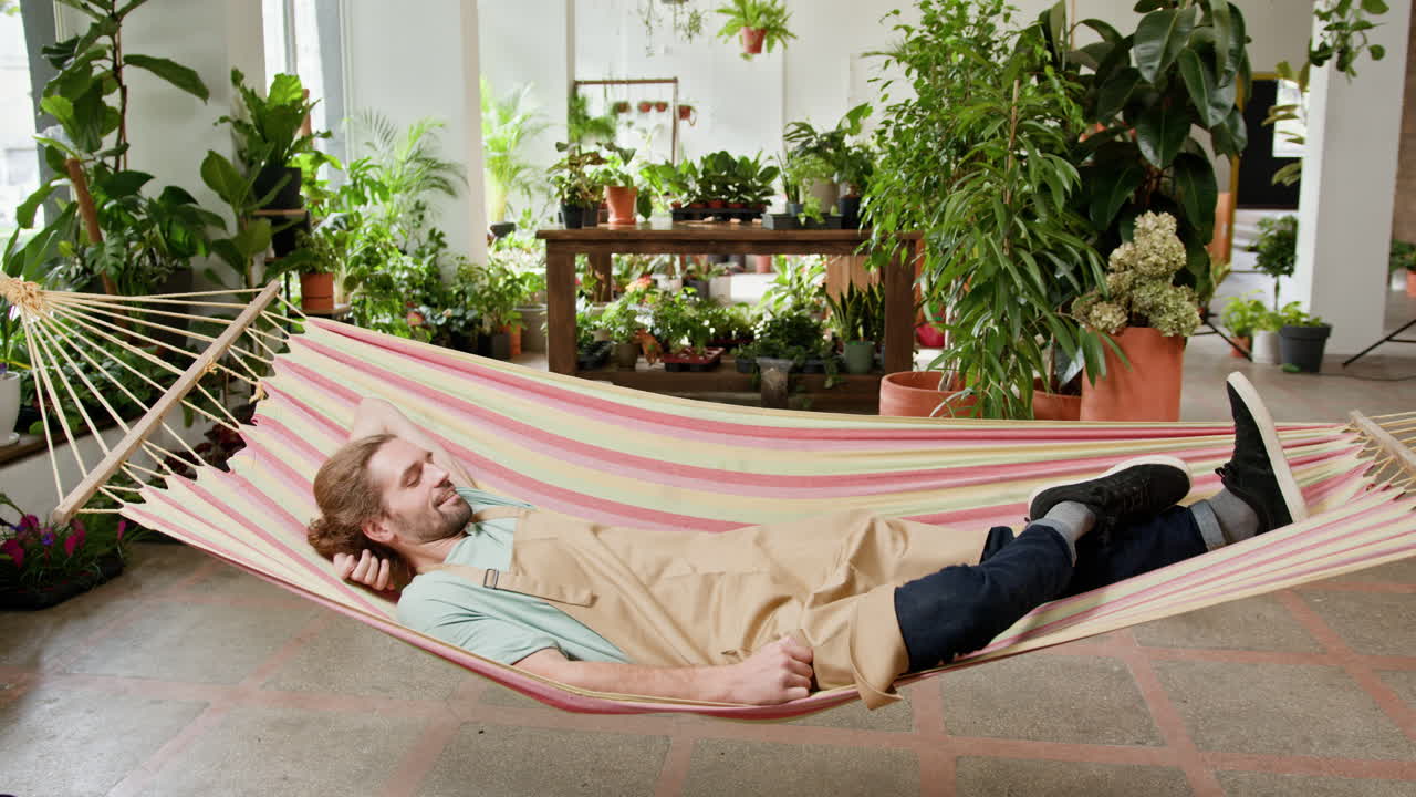 hombre relajándose en una hamaca en una tienda de flores