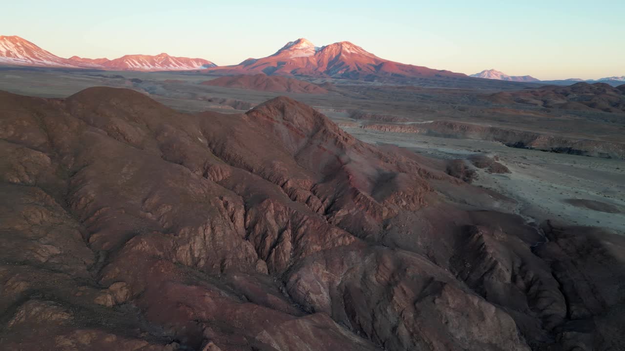 Aerial shot of the Atacama Desert highlands, illuminated by warm evening light over the Andes