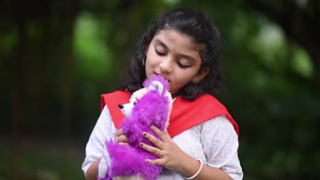 A-cute-little-Asian-girl-is-playing-with-her-teddy-bear-in-a-forest-alone-on-Halloween-day