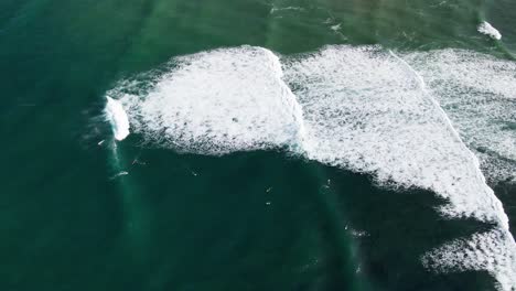 Aerial-View-of-Surfers-catching-and-surfing-waves-at-Parlamentia-Surf-Break-in-French-Basque-Country-close-to-Biarritz