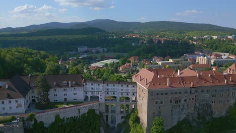 Perfect-aerial-top-view-flight-House-on-arch-bridge,-Krumlov-Cesky-castle-on-the-hill-castlein-in-czech-republic-in-Europe,-summer-of-2023