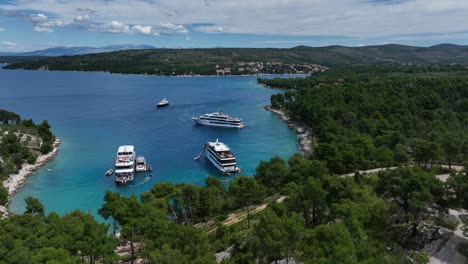 aerial: hvar island during the day with adriatic sea, big white yachts and forest in croatia, orbit drone shot