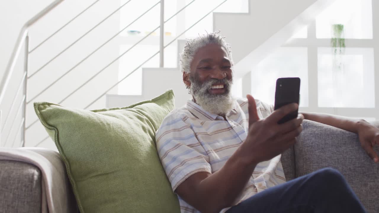 Senior man having a video chat on his smartphone at home