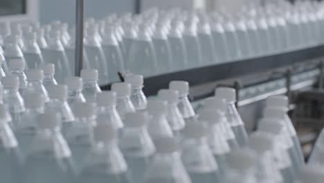 cinta transportadora con botellas de agua potable en una planta de bebidas moderna