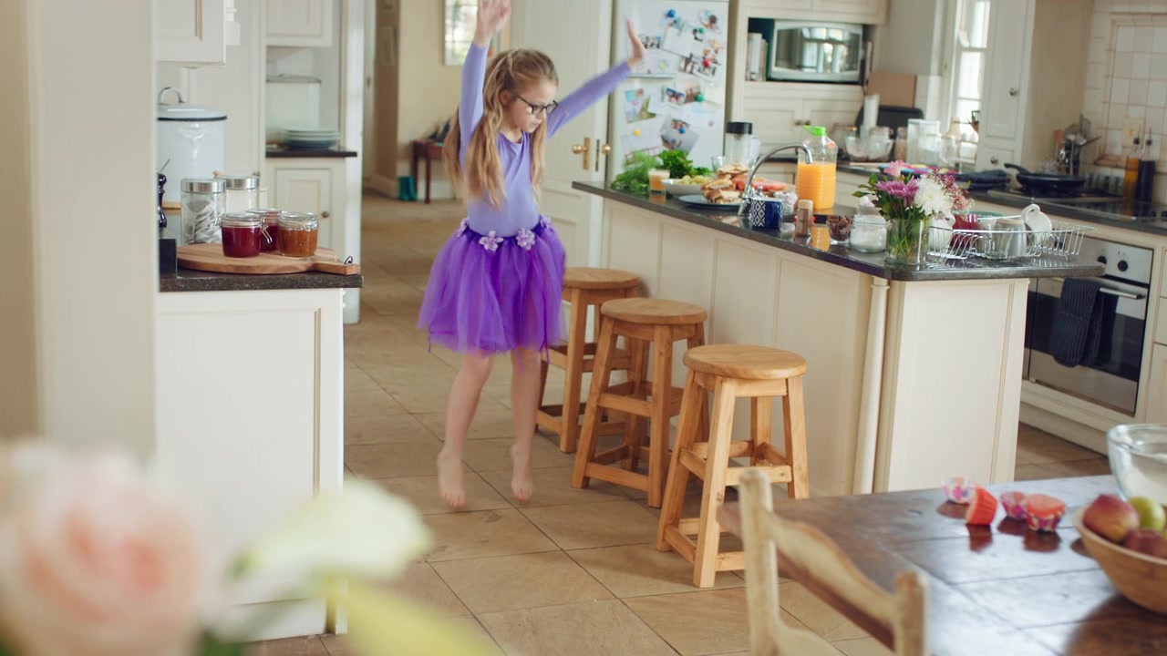 Bambina che balla in cucina