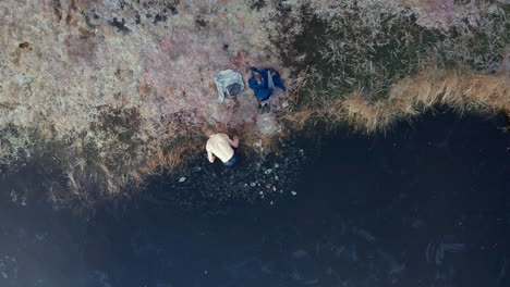 AERIAL-TOP-DOWN---An-ice-bather-finishes-his-practice-and-exits-the-water