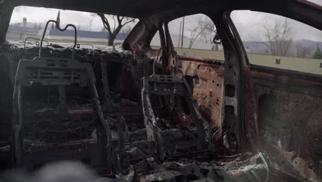 interior del coche después de haber pasado por un terrible incendio forestal dejando intacto solo el marco metálico de los asientos - 4k