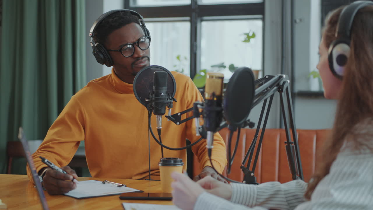 Black Podcast Host Recording Interview with Female Guest at Studio