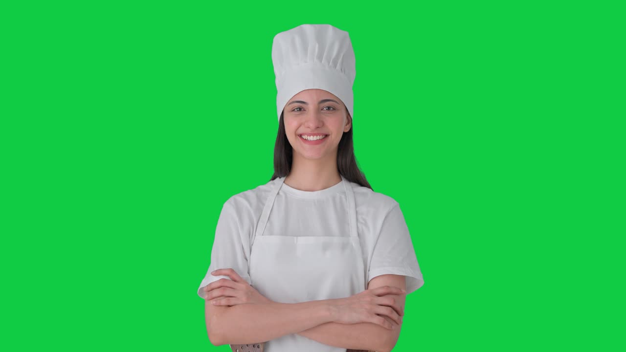 Ritratto di chef professionista indiana felice su schermo verde