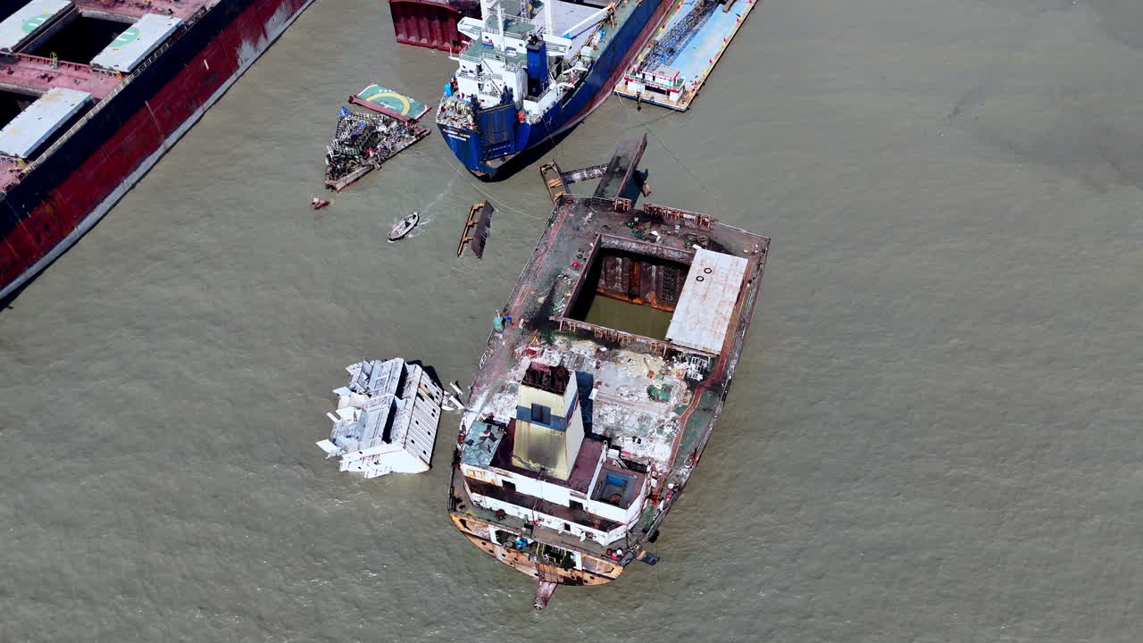 Cinematic panning drone shot of a large ship and wreckage abandoned in a ship graveyard in Bangladesh