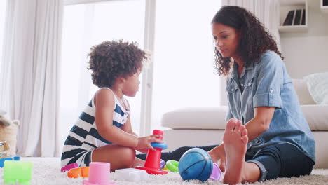 Una-Joven-Negra-Y-Su-Hija-Jugando-Con-Anillos-De-Plástico.