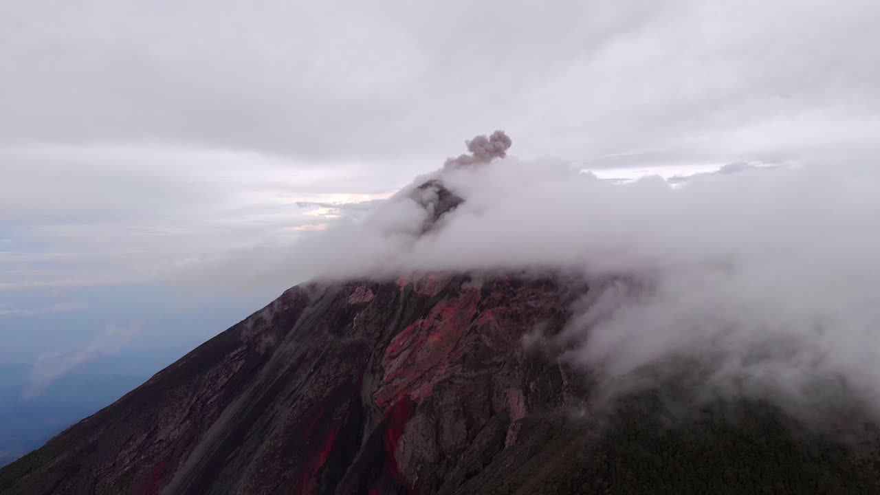 un dron captura la pequeña erupción del volcán de fuego, envuelto en nubes, cerca de antigua, guatemala