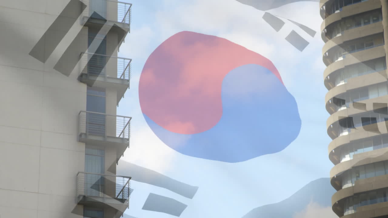 Waving South Korean flag over modern apartment buildings under blue sky
