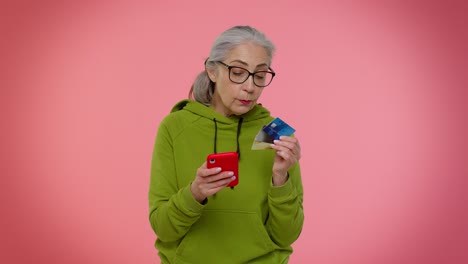 smiling woman holding a phone and credit cards