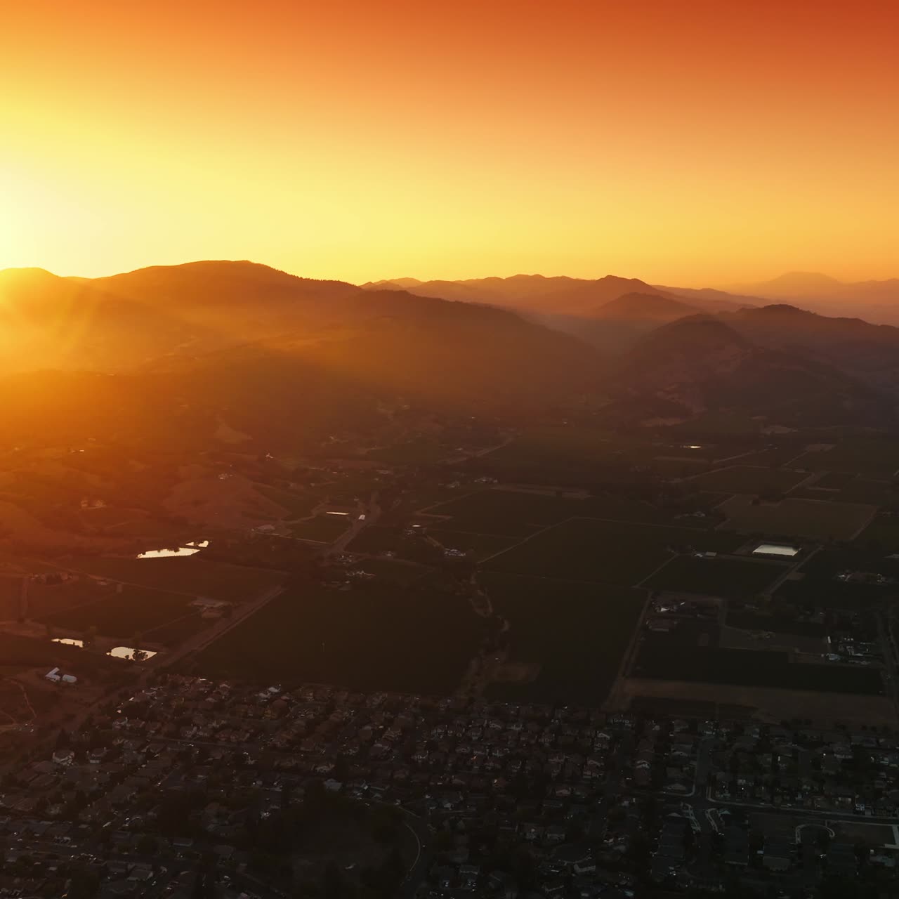 Scenery of picturesque Napa, California, USA in the rays of setting sun. Amazing city at the backdrop of mountains and orange skies