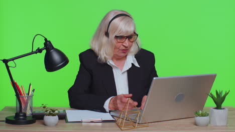 senior businesswoman in headphones making conference video call on laptop call center agent operator