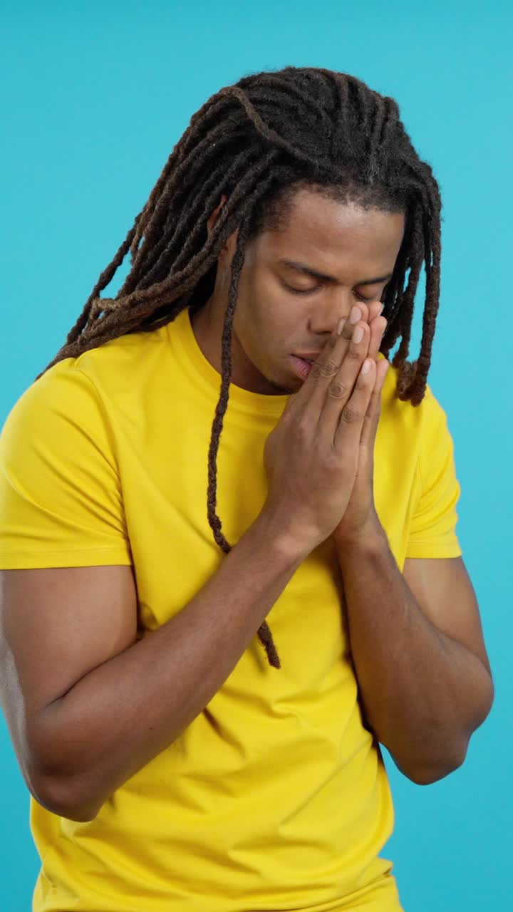 Man praying with dreadlocks