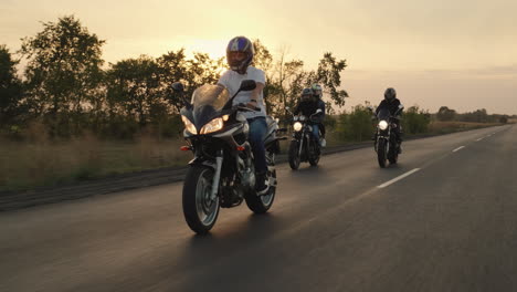 a group of bikers ride on motorcycles on the highway 1