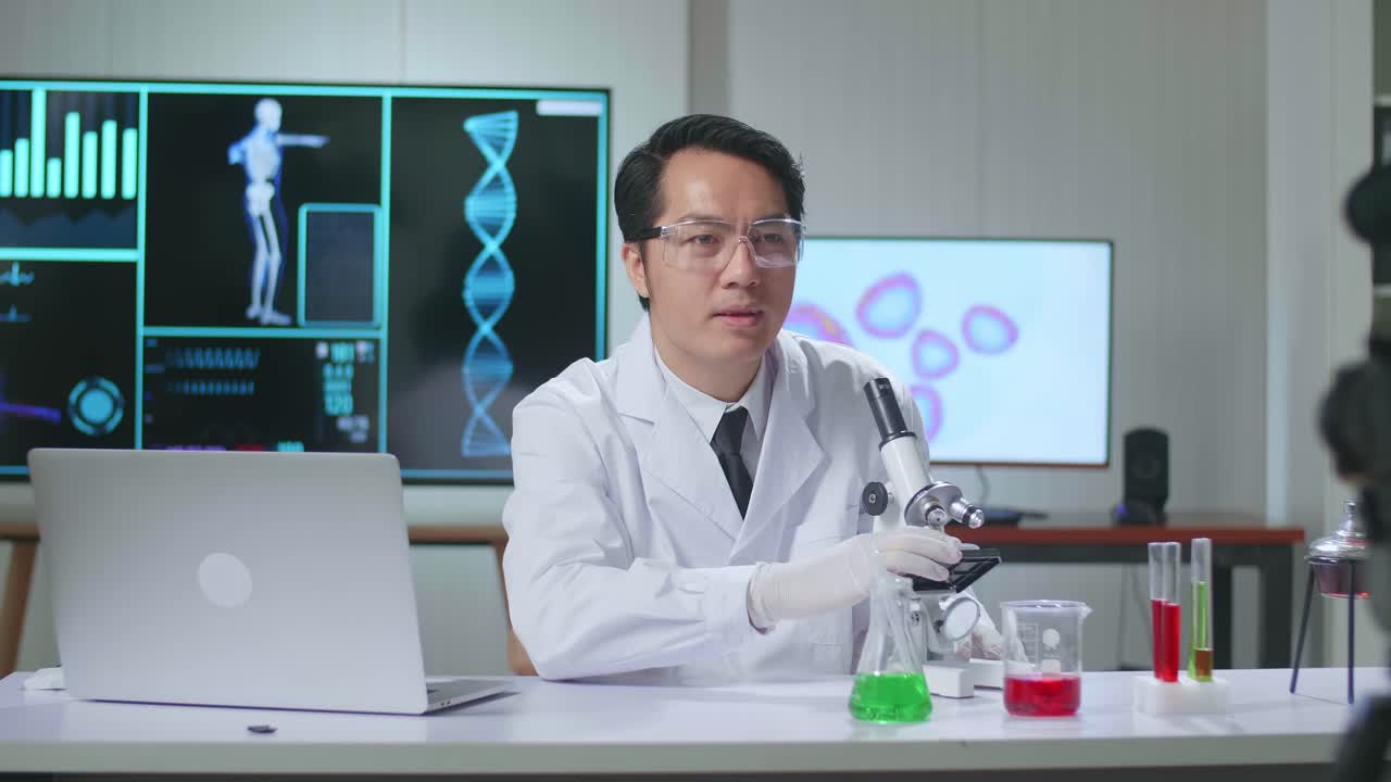 Asian Scientist Man Holding Petri Dish And Talking To Camera