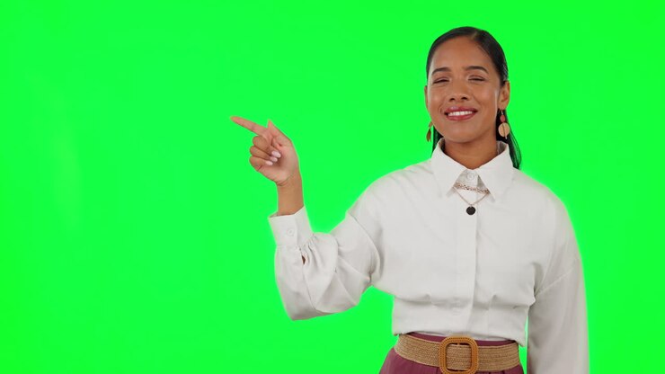 Happy woman, hands and pointing on green screen
