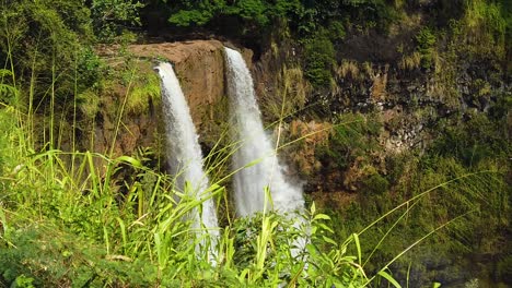 hd slow motion hawaii kauai slow boom up of wailua falls with tall grass in foreground