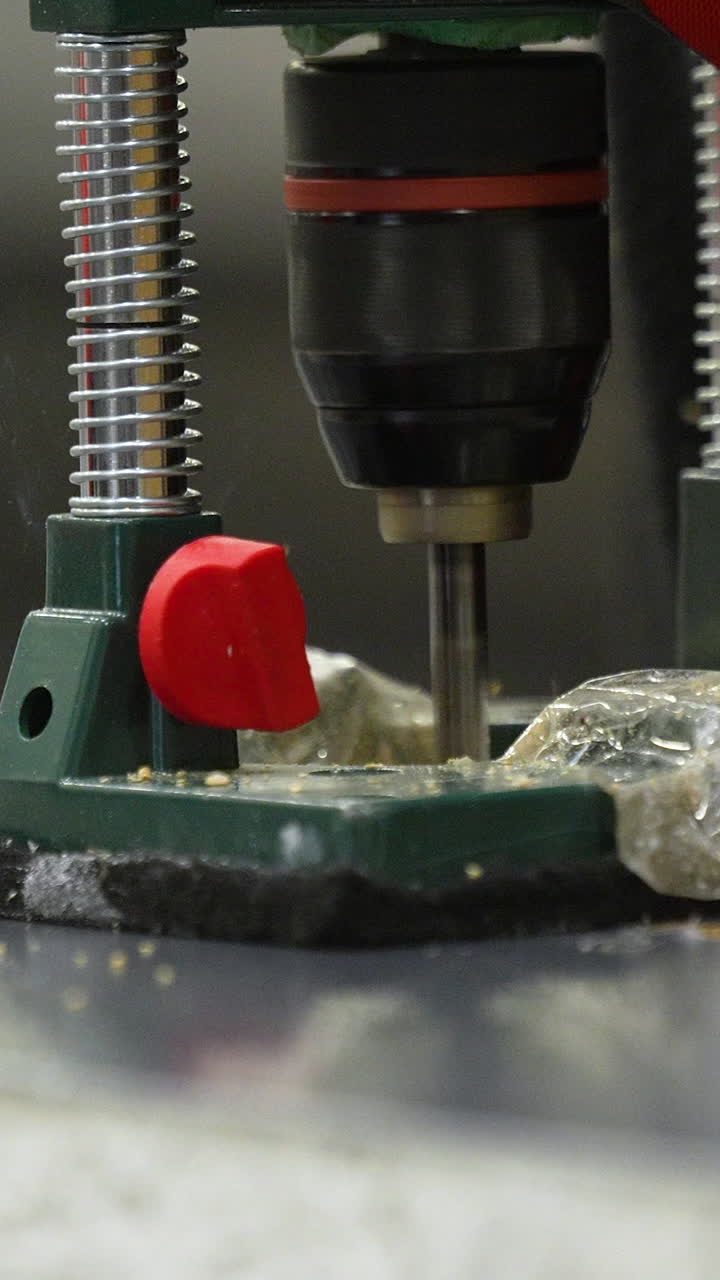 Macro shot of a power drill bit rotating and plunging into wood, showing sawdust and mechanical movement. Perfect for construction and DIY craft videos