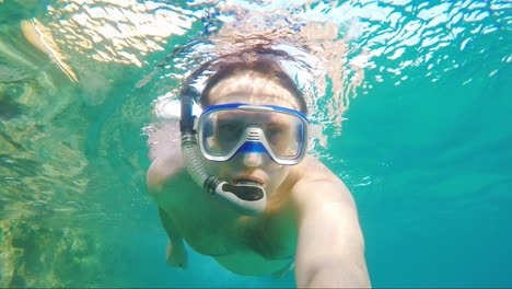 un hombre nada bajo el agua con una máscara para bucear