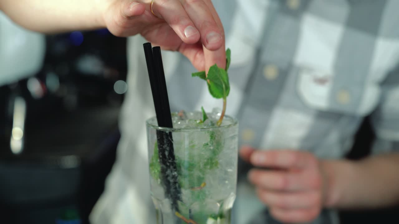 Processo di preparazione di un cocktail Mojito con ghiaccio. Barman al lavoro mentre prepara cocktail
