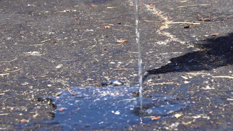 a high angle of water on warm blacktop cement in the summer sun