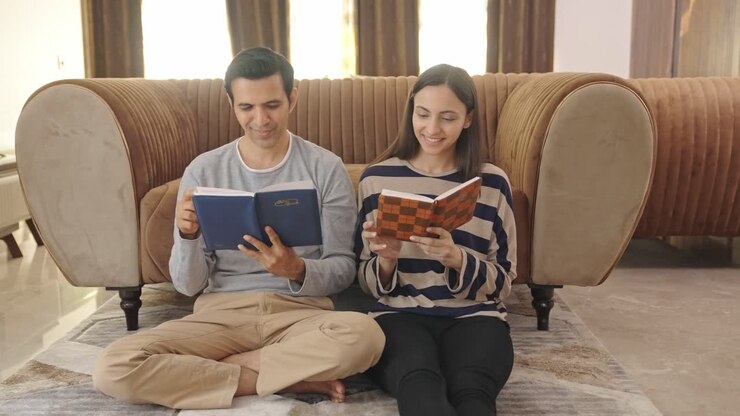 una pareja india feliz leyendo diferentes libros