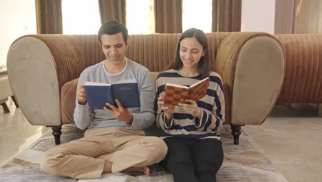 Happy-Indian-couple-reading-different-books