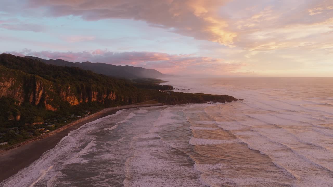 vista aérea ascendente de las rocas de panqueque de punakaiki durante la puesta de sol brillante sobre el paisaje costero, la playa y el mar de tasmania en la costa oeste de la isla sur, nueva zelanda aotearoa