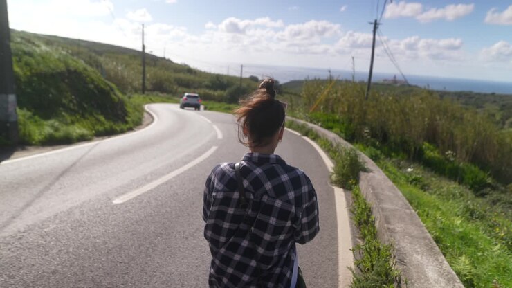 Donna che cammina su una strada di montagna panoramica